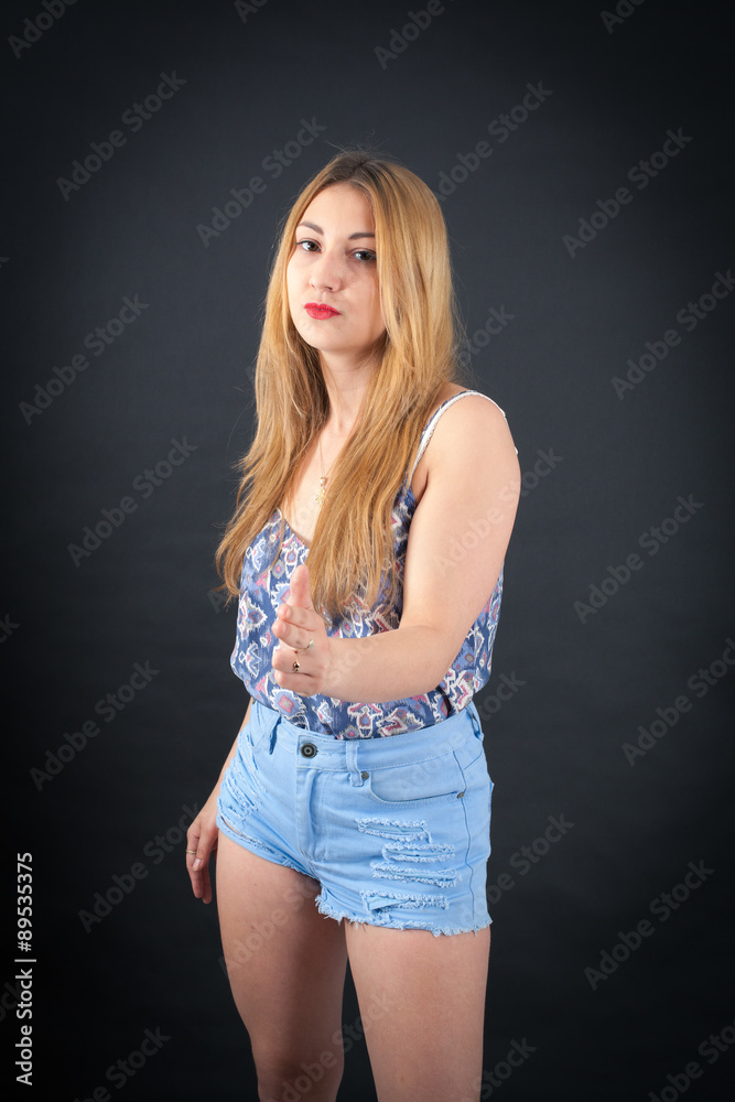 Beautiful girl doing different expressions in different sets of clothes: gun sign Beautiful girl doing different expressions in different sets of clothes: gun sign