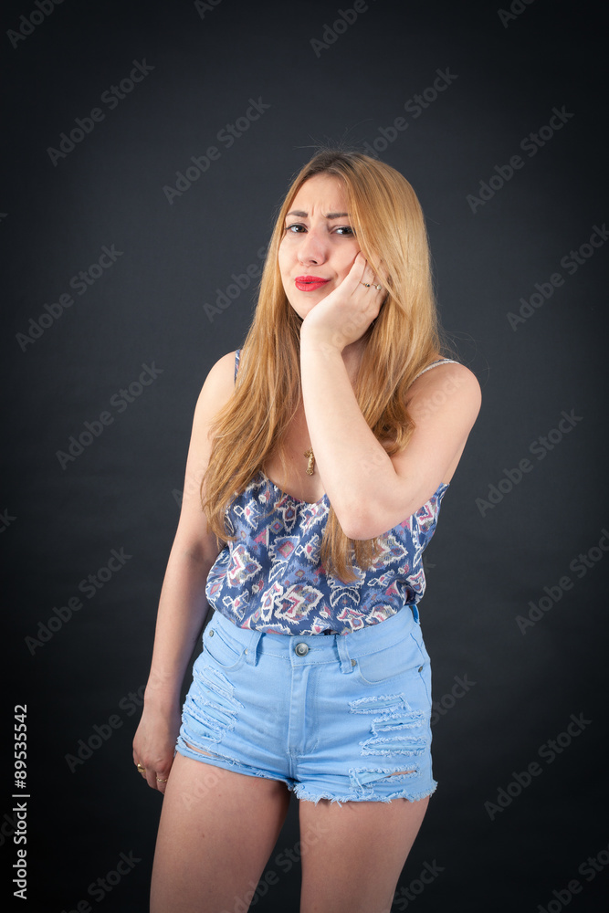 Beautiful girl doing different expressions in different sets of clothes: toothache Beautiful girl doing different expressions in different sets of clothes: toothache