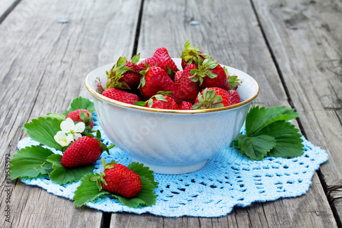Fresh strawberries in a bowl on blue napkin