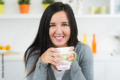 Φωτογραφία lächelnde junge frau trinkt tee