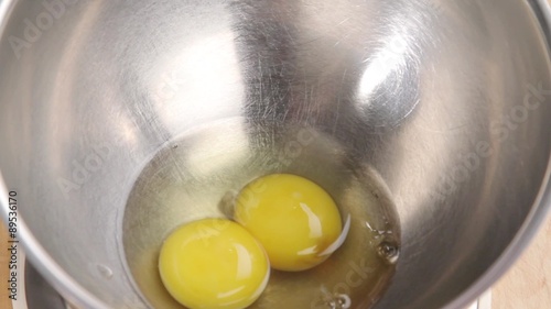 Crack eggs into a mixing bowl