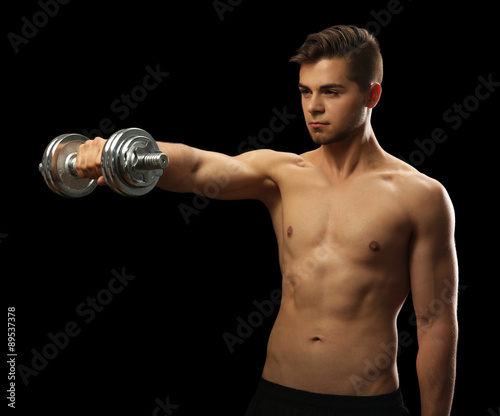 Muscle young man holding du...
