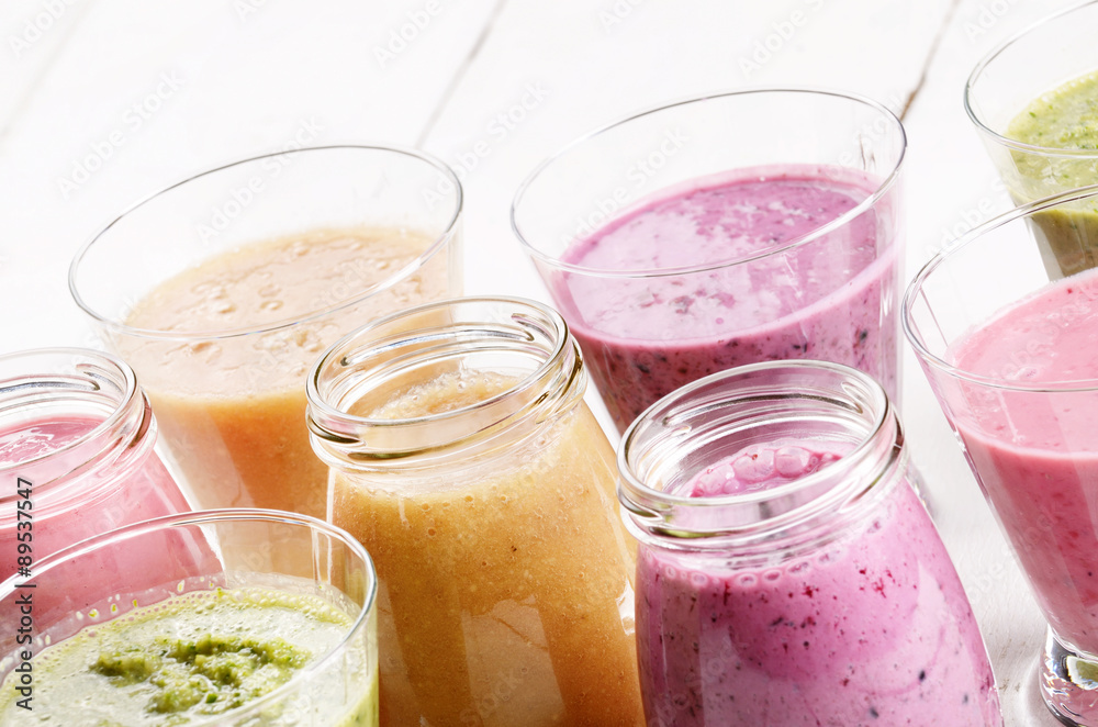 Assorted fruit and vegetable shakes on white table Assorted fruit and vegetable shakes on white table