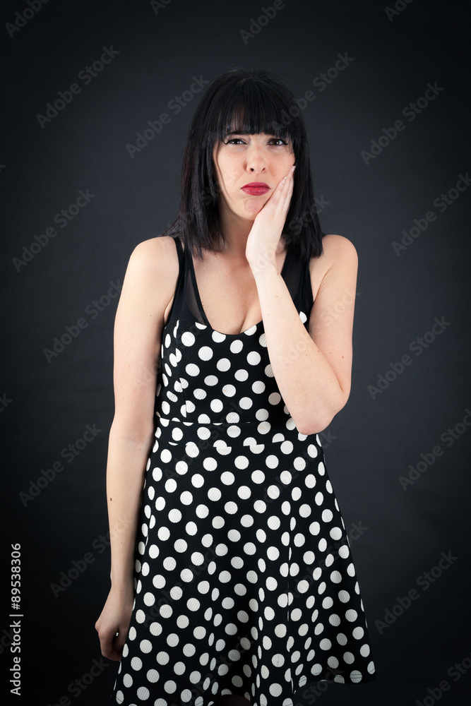 Beautiful woman doing different expressions in different sets of clothes: toothache Beautiful woman doing different expressions in different sets of clothes: toothache