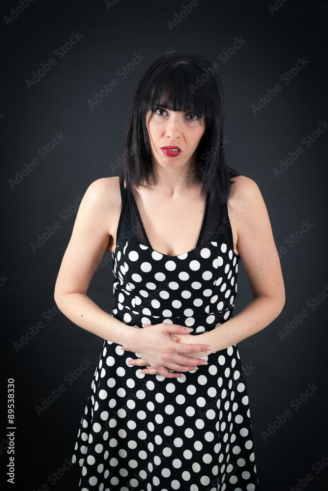 Beautiful woman doing different expressions in different sets of clothes: stomachache Beautiful woman doing different expressions in different sets of clothes: stomachache