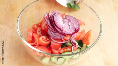 Ingredients for vegetable salad being placed in a bowl