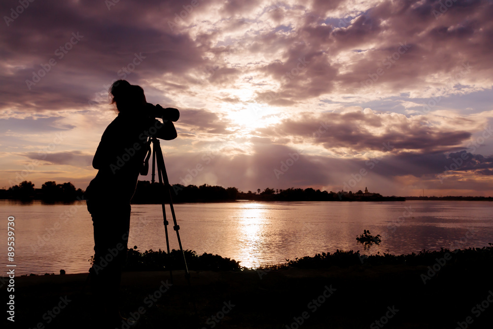 silhouette of photographer taking photo at sunset