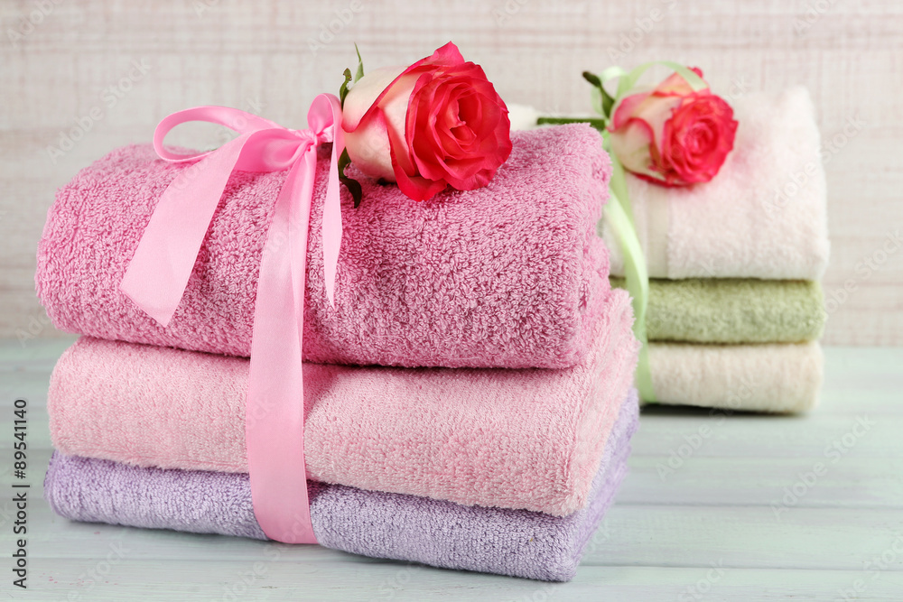 Stack of colorful towels on light wooden background Stack of colorful towels on light wooden background