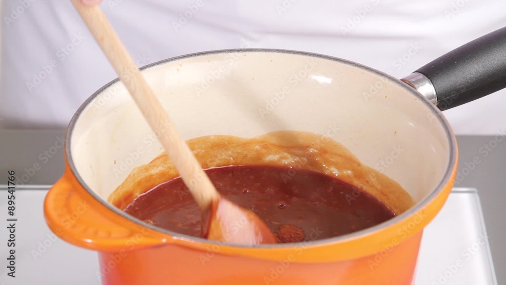 Barbecue sauce being spiced with chilli powder Barbecue sauce being spiced with chilli powder