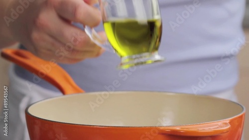 Oil being added to a saucepan