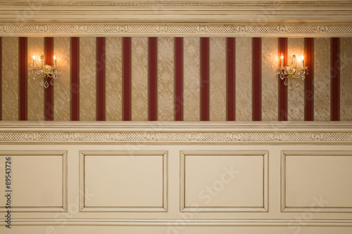 Foto Formal interior wall with wallpaper, sconces and paneling