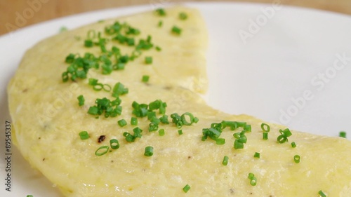 An omelette being sprinkled with chives
