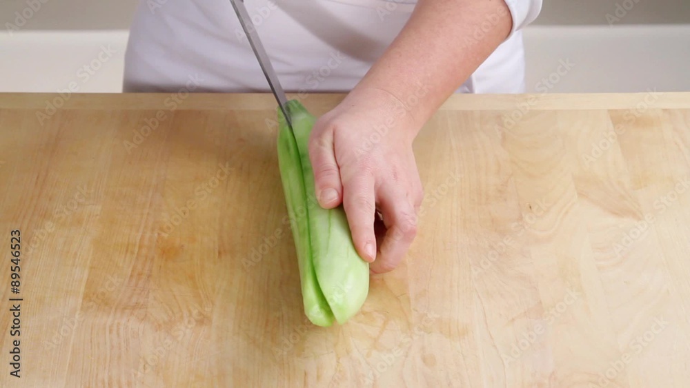 A cucumber being halved lengthways