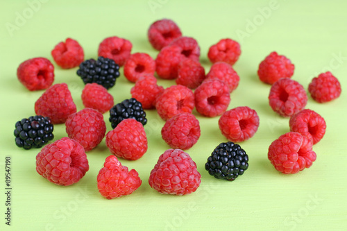 raspberries and blackberries on a light green background