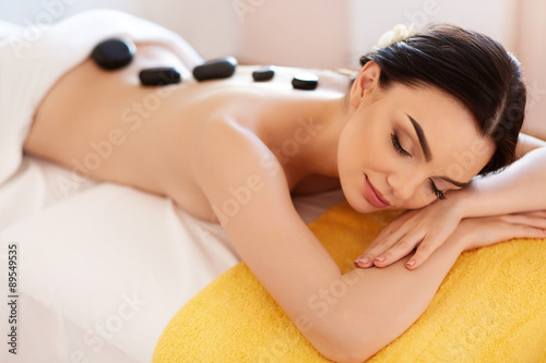 Foto Spa Stone Massage. Young Woman Have Hot Stone Massage Treatments
