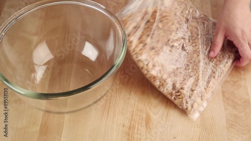 Biscuit crumbs being placed in a glass bowl