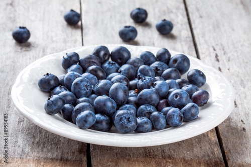 juicy fresh organic blueberries in a plate on a wooden table