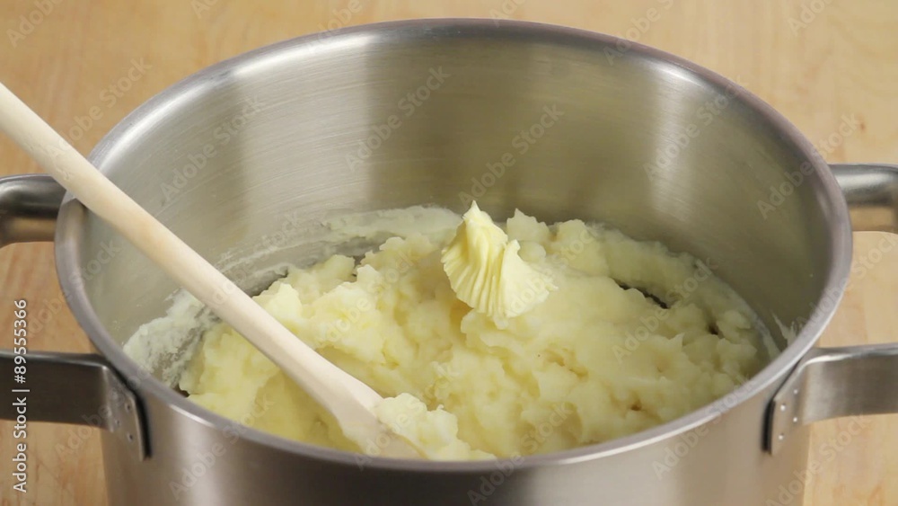 Butter being added to mashed potatoes Butter being added to mashed potatoes