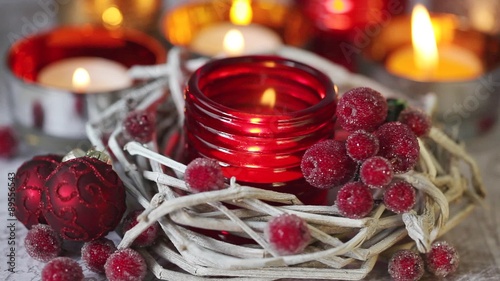 A tealight in a red glass holder and Christmas decorations photo