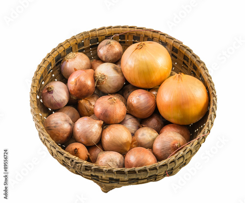 onions and shallots in old basket isolated on white background