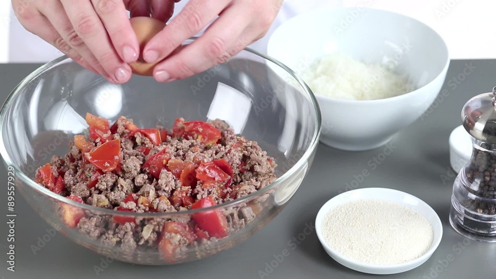 Grated cheese being added to a minced meat and tomato mixture Grated cheese being added to a minced meat and tomato mixture