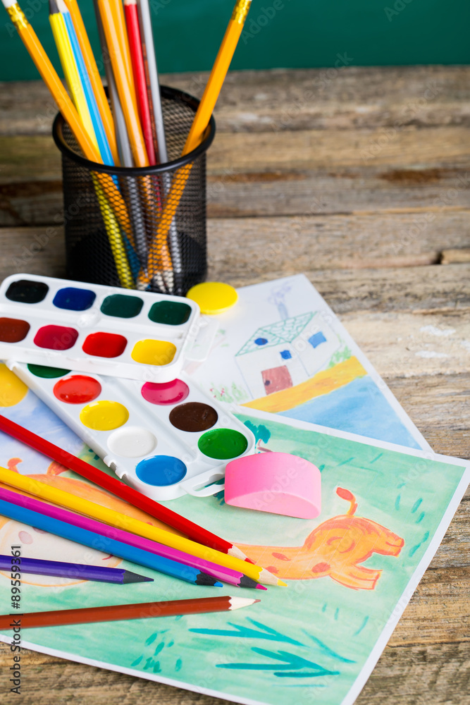 school objects. painting pictures on wooden desk
