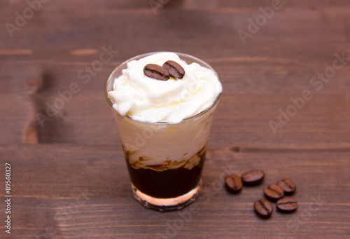 Glass with coffee and cream on wooden table