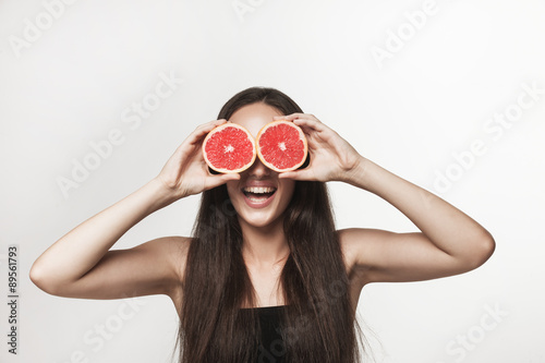 Funny image of young woman holding grapefruit