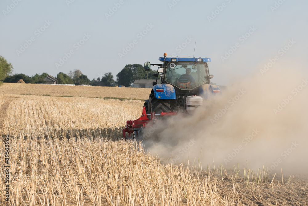 Fototapeta premium Farmer in tractor preparing land for sowing 