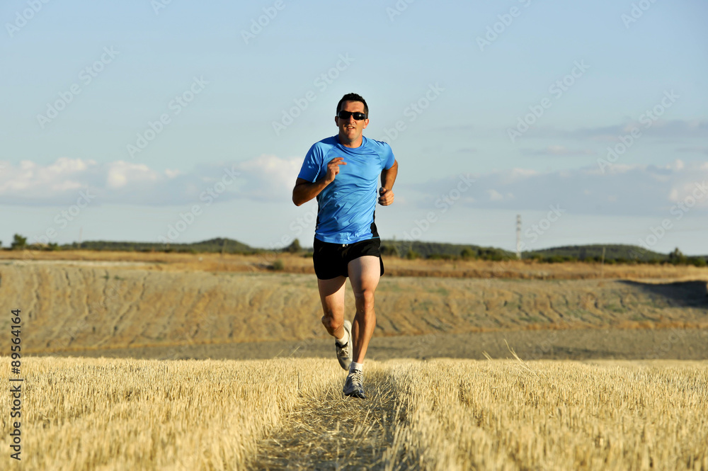 sport man with sunglasses running outdoors on straw field ground in frontal perspective sport man with sunglasses running outdoors on straw field ground in frontal perspective