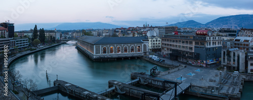 Panoramic of Geneva at dusk. 
The Seujet dam, the Rhone river and the city.