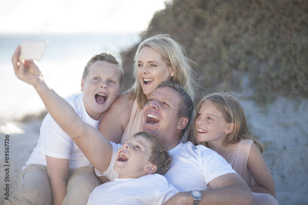 Happy family together on a beach taking a selfie Happy family together on a beach taking a selfie