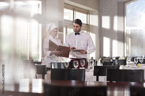 Chef and waiter in restaurant discussing menu photo