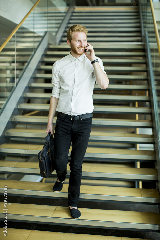 Fototapeta premium Young businessman on the stairs
