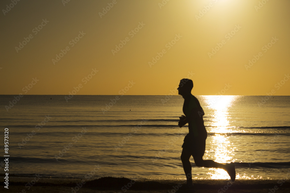 man running on the beach at dawn