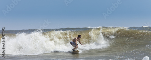 muscular man surfing large Atlantic waves © Wollwerth Imagery