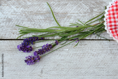 white grey old wooden shelves background with lavender flowers decoration on a checked doily  