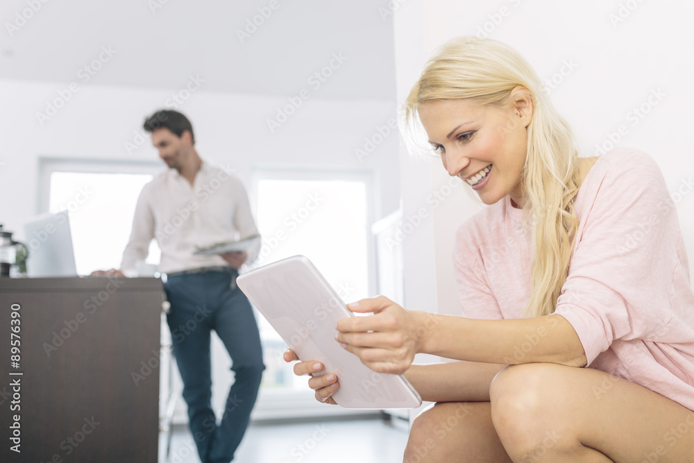 Smiling young woman with digital tablet at home Smiling young woman with digital tablet at home
