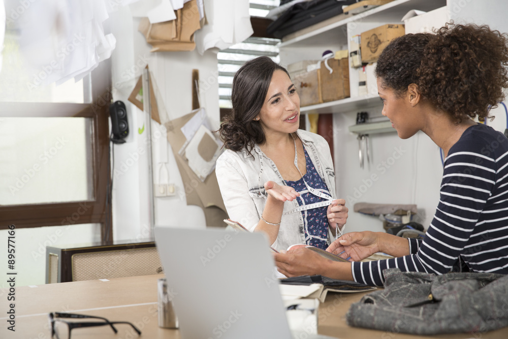 Fashion designer and seamstress working in workshop Fashion designer and seamstress working in workshop