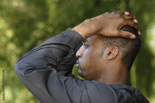 Profile of upset young man with his hands on his head.