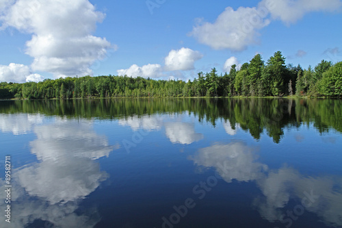 Puffy Clouds Reflected in Calm Lake © kmm7553