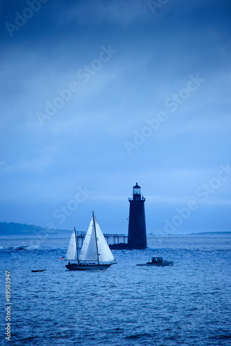 Sailboat passing by Ram Island Ledge Lighthouse.