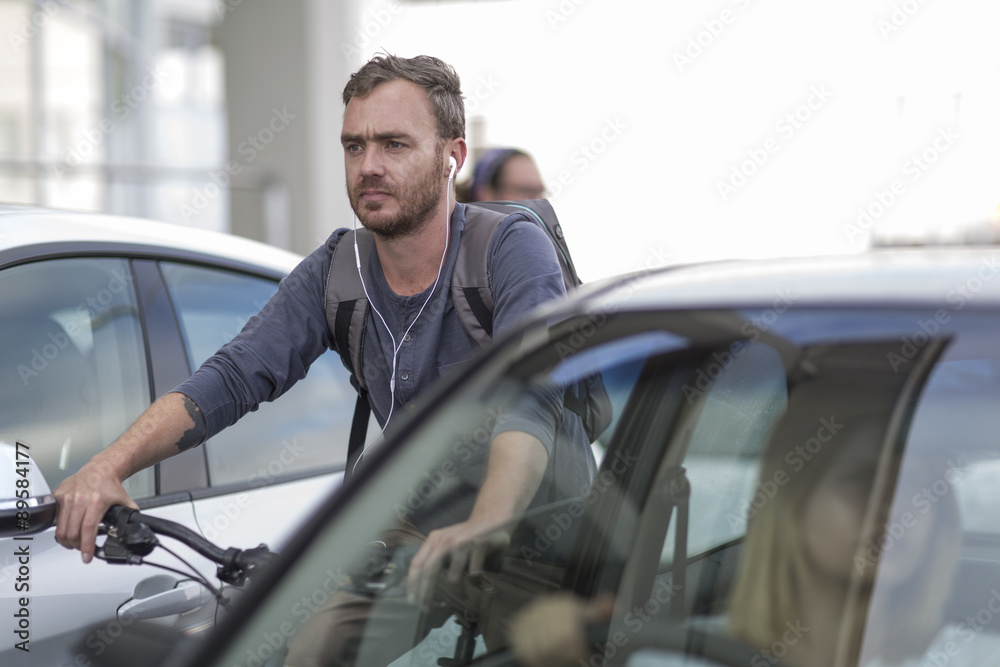 Man on bicycle in traffic jam