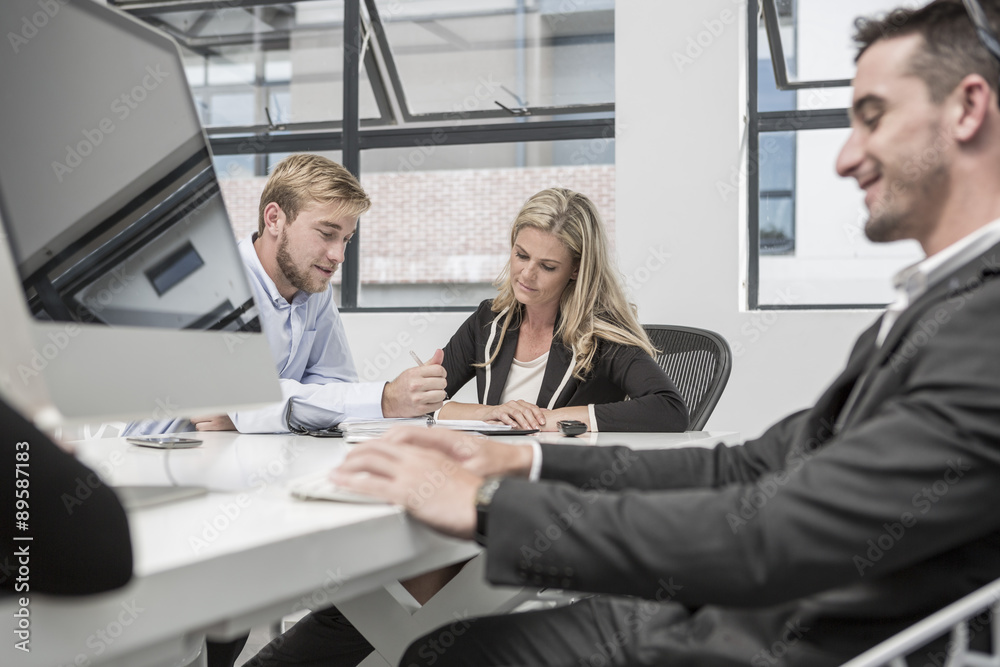 Three businesspeople working in meeting room Three businesspeople working in meeting room