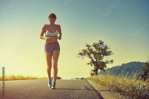 Running woman at sunrise or sunset