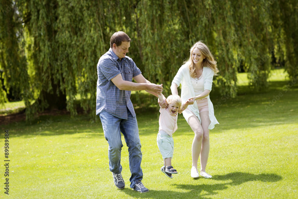 Parents playing with their little son in a park Parents playing with their little son in a park