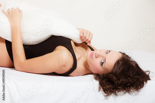 Sexy girl lazy woman with pillow on bed in bedroom