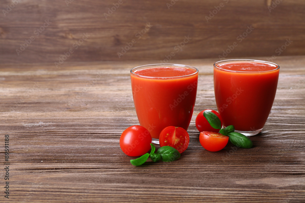 Glasses of tomato juice with vegetables on wooden background Glasses of tomato juice with vegetables on wooden background