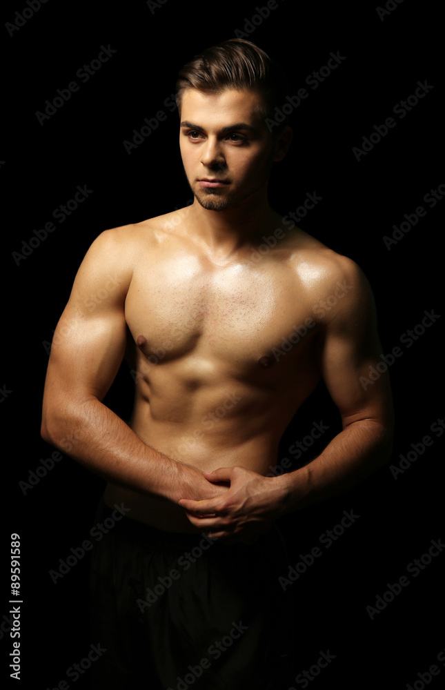 Muscle young man on dark background