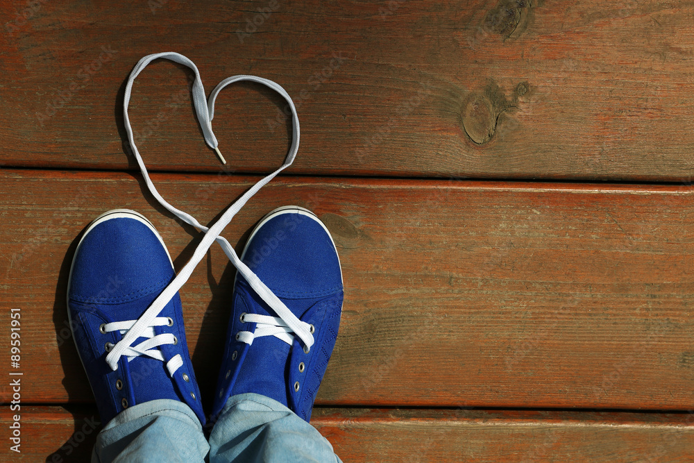 Female feet in gum shoes on wooden floor background Female feet in gum shoes on wooden floor background